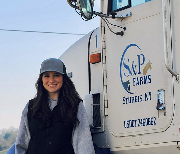 woman standing by an agriculture truck