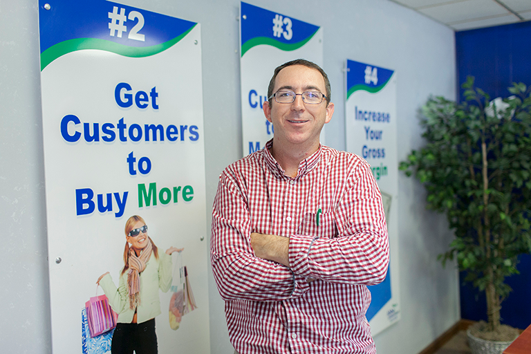 Man posing in front of marketing/business banners
