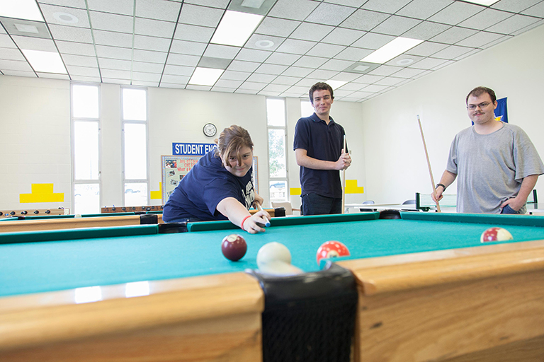 Three students playing pool