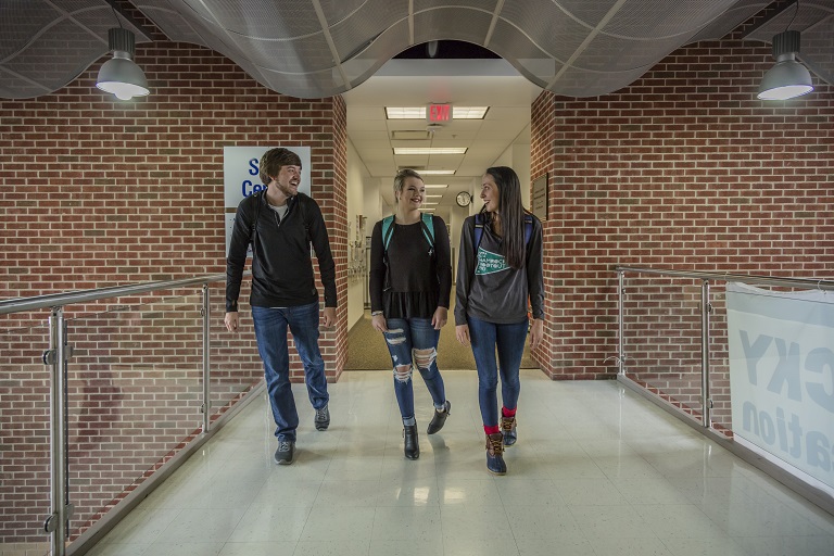 three students walking in a hallway