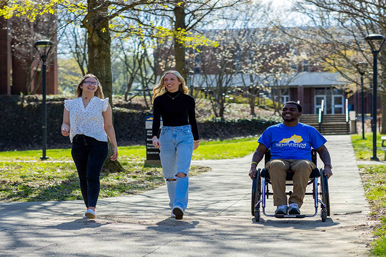 three students outside on campus