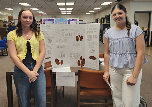 students standing by a display at a table