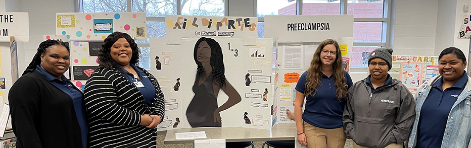 students standing around a presentation board