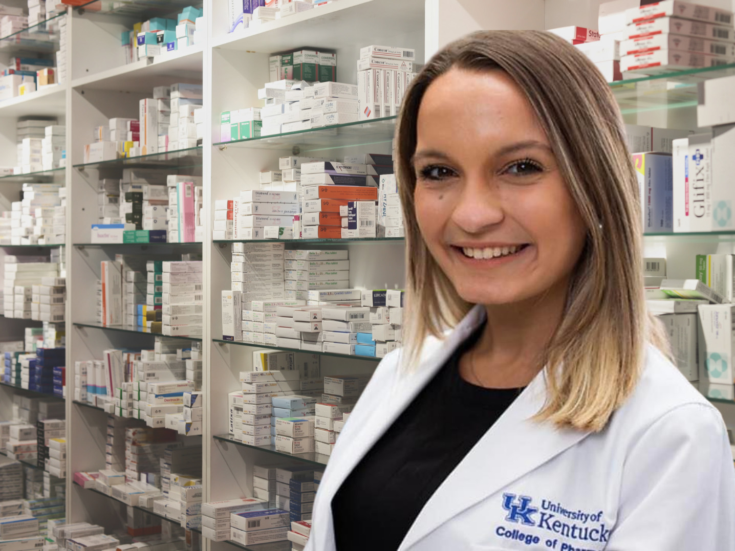 Female student wearing lab coat in a pharmacy