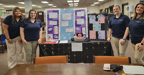 students standing by a table display