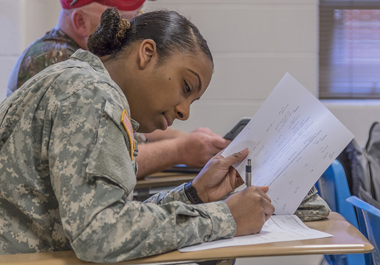 army student writing on a desk