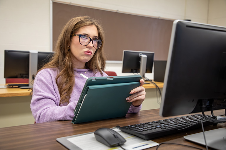 a female student sitting at a computer