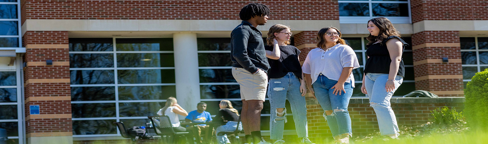 Four students standing outside the HCC campus