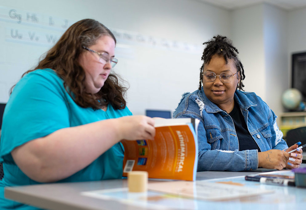 adult education instructor helping a student