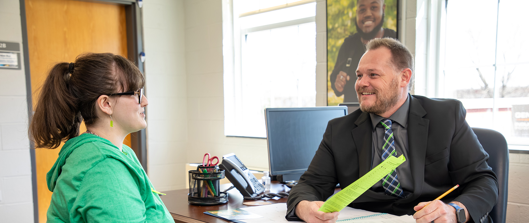 an instructor and a student sitting in his office