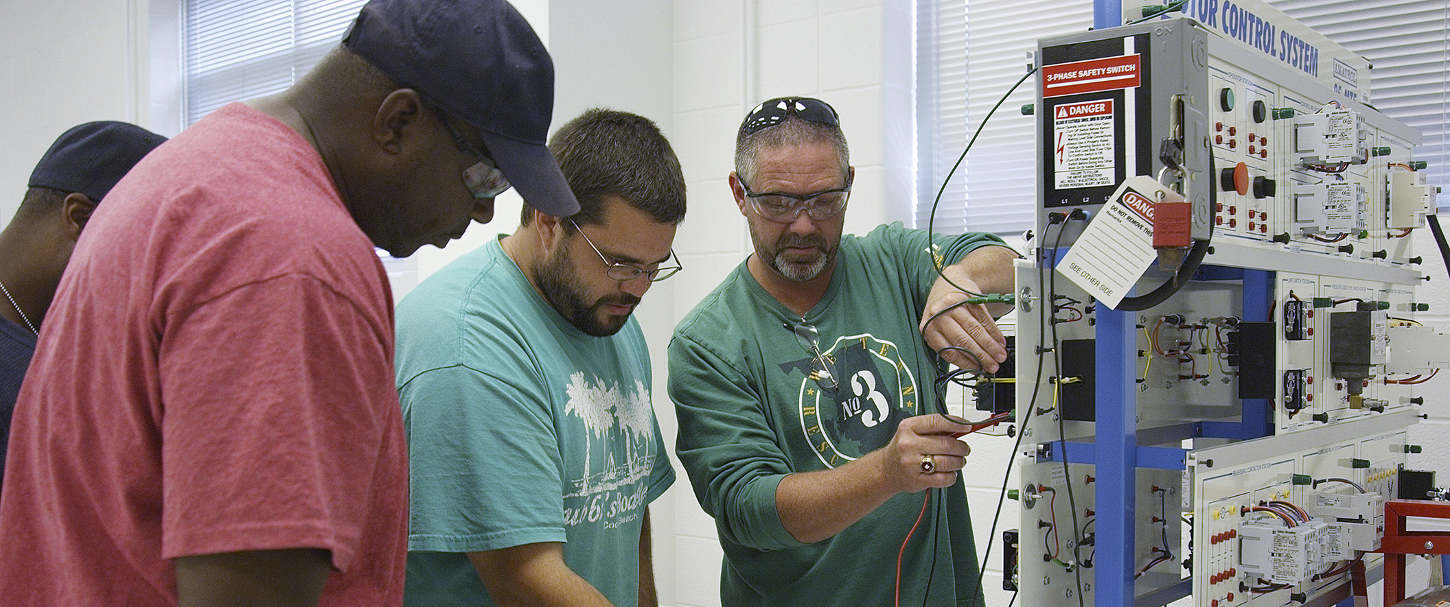 three men inspecting electrical equipment
