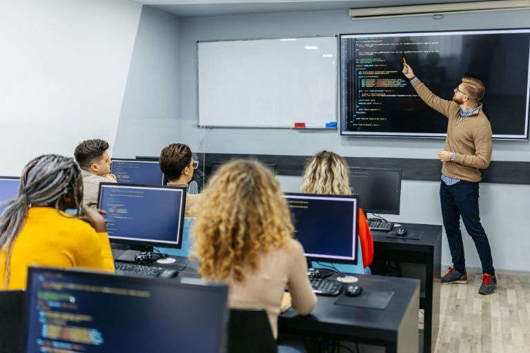 Lecturing teacher pointing to large screen