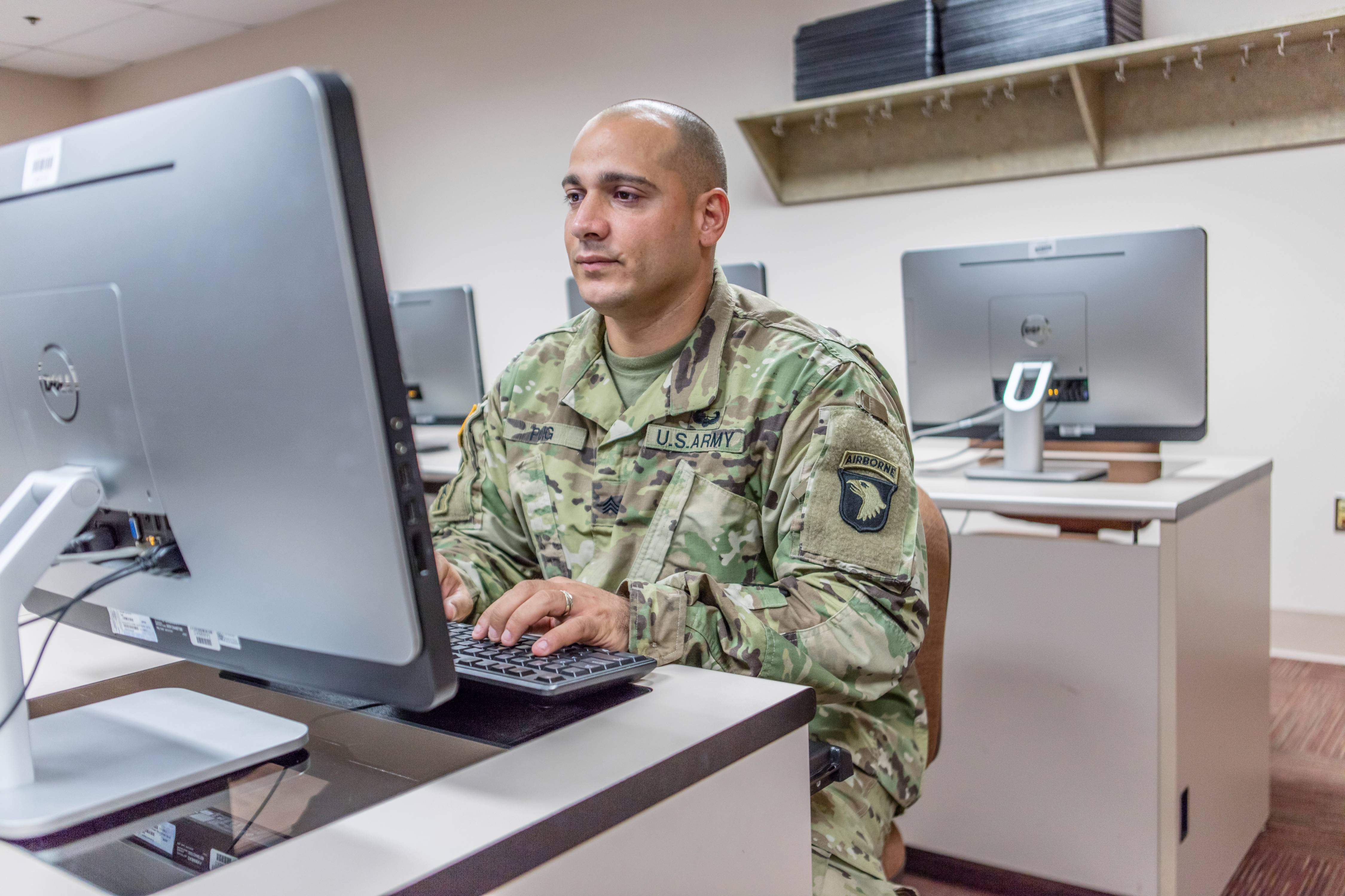 Man in fatigues sitting at computer