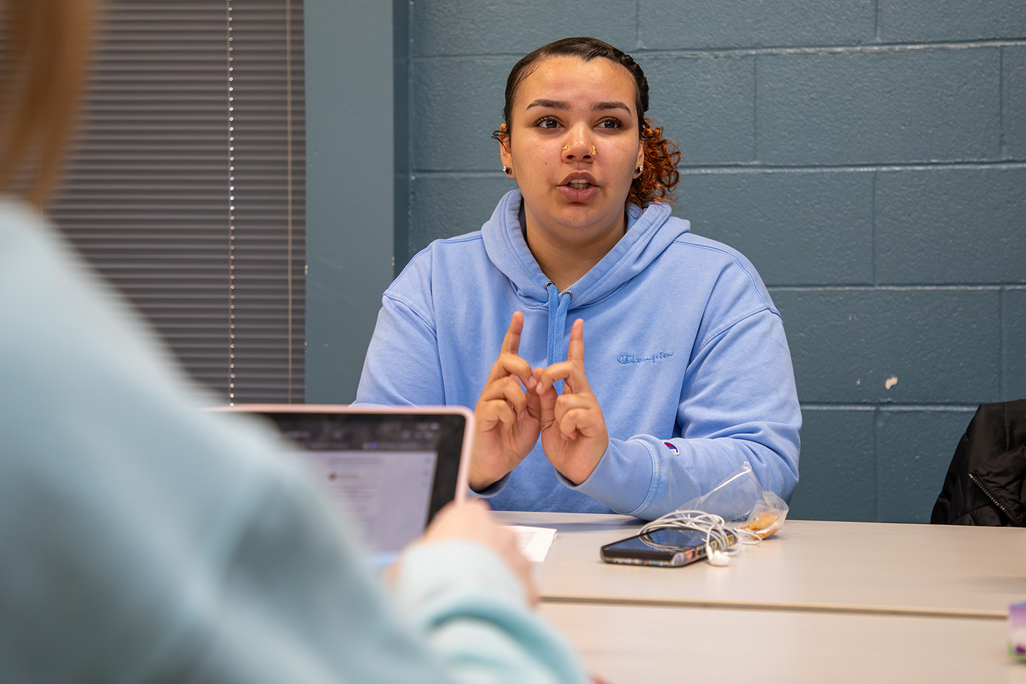 a student at a desk talking