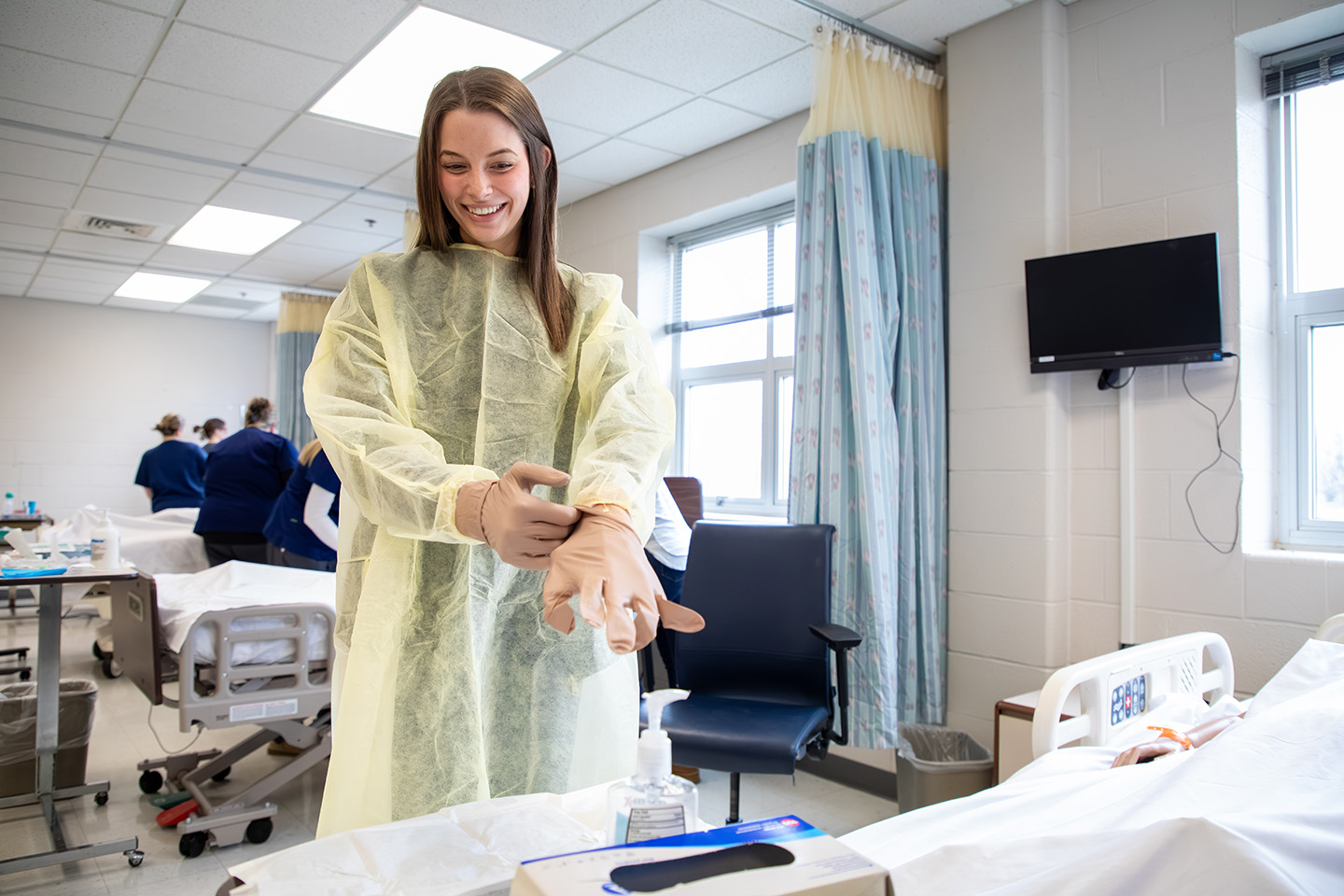 a nursing student putting on gloves